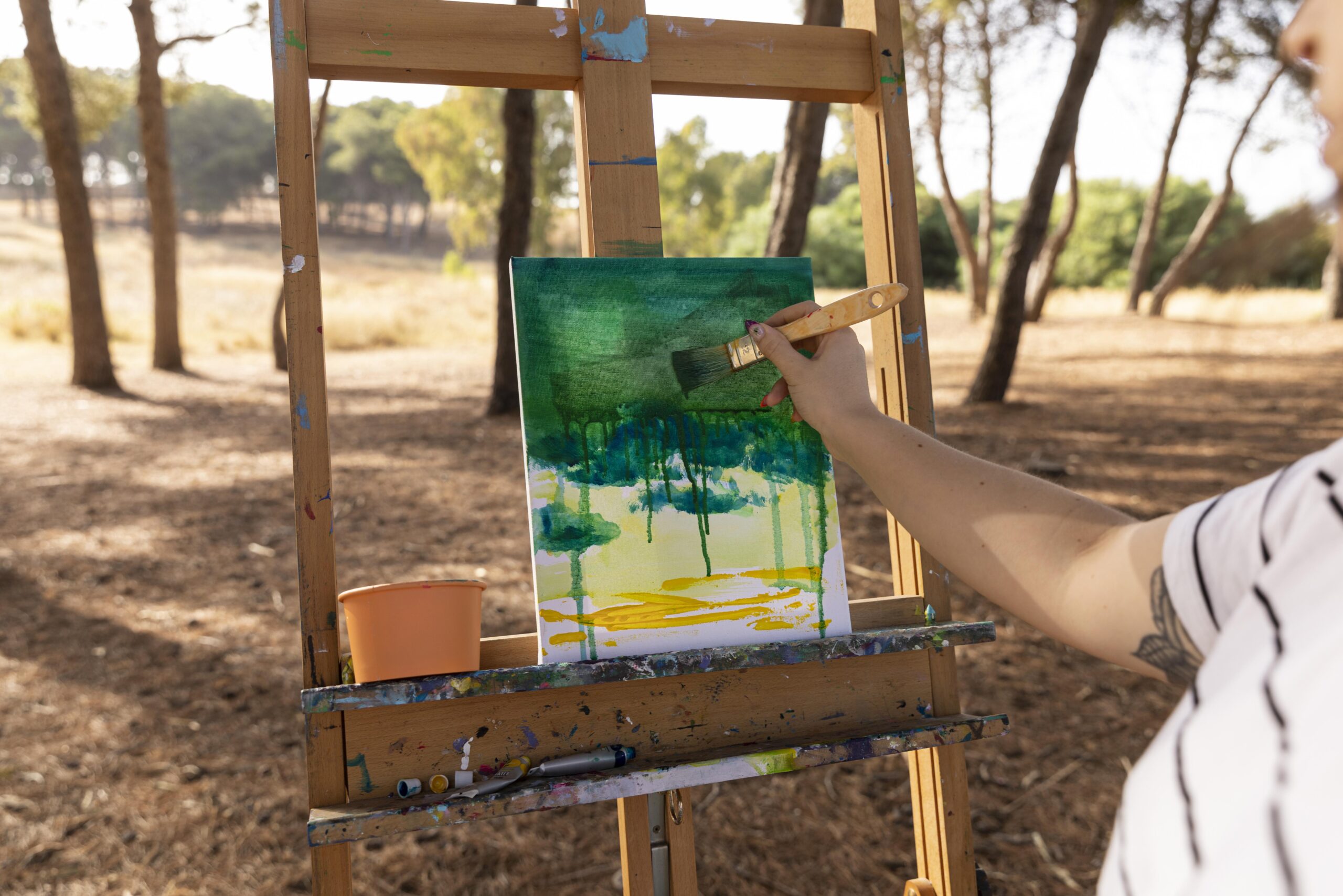 Painter working on a canvas in the outdoors