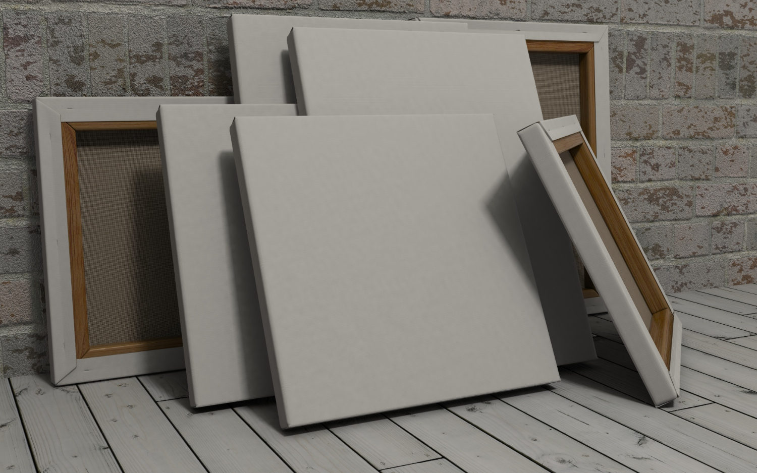 A set of blank canvases stacked against a wall.