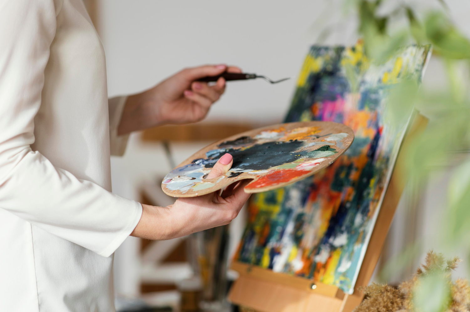 Young blonde woman painting with acrylics.